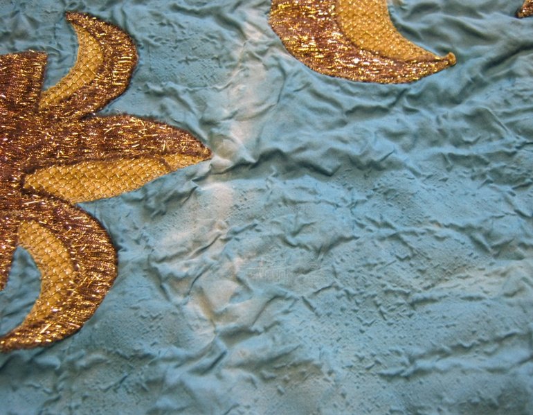 Detail of drape, showing wrinkled surface of fabric and distortion of colour caused by adhesive.