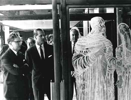 HRH Prince Philip and Levi Fox are looking at an exhibition case on the right, which contains wraith-like figures of Shakespearean characters.