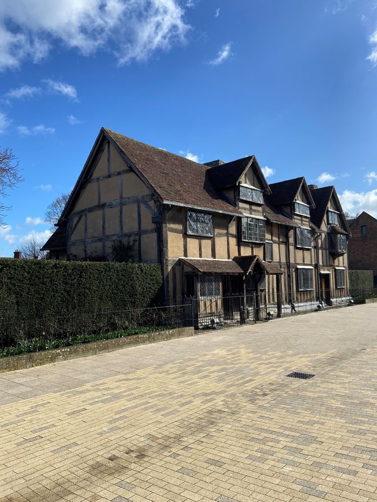 Shakespeare's Birthplace in the sun, sitting inbetween some freshly trimmed hedges.