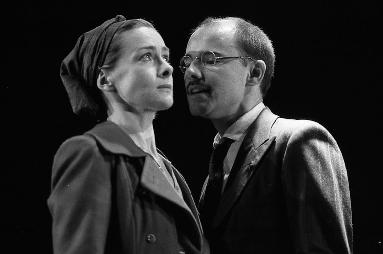 Measure for Measure Angelo, played by Daniel Evans, attempts to blackmail Isabella, whose religious fervour and inner strength is shown to be unshakeable. Isabella looks heavenward with a blank face but an air of worry, while Angelo (with rimless glasses) approaches mush too close on her left.