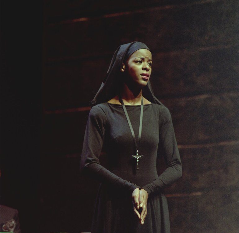 Measure for Measure Royal Shakespeare Company, 1987 Dressed in a nun's habit, an African Isabella, spotlit against a dark background, gazes half-left looking sorrowful and troubled.