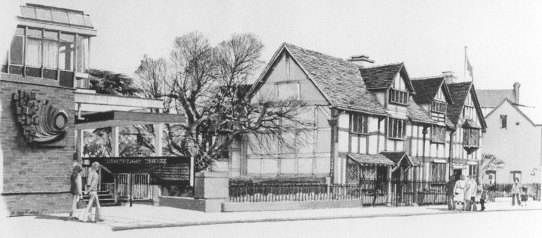 Scott Jones Shakespeare Centre is on the left, with the Birthplace on the right. Only the end of the centre is shown, brick-built with a fully-glazed upper storey and a sculpture on the wall. The mulberry tree stands between the Centre and the Birthplace.