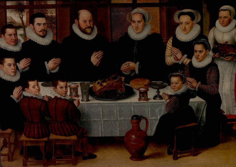 A Family Saying Grace Before a Meal. As we face the table, all the men are on the left, all the ladies on the right; the children are at the front of the table, the master and mistress in the centre behind the table. A serving maid hovers in the background to the right, not praying; she is wearing white, everyone else is in dark clothing. All have ruffs.