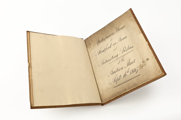 The opened catalogue with yellowing paper displays the page proclaiming "Shakespeare's House in Stratford on Avon and Interesting Relics", with the place and date of the auction.