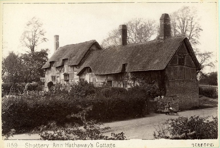 Seen from the road, the cottage is half-hidden by a very overgrown hedge. The further, taller, section is clearer, and the beams are visible, although not painted black; a small bay window is also visible. The winter light and the bare trees showing above the cottage give a feeling of desolation.