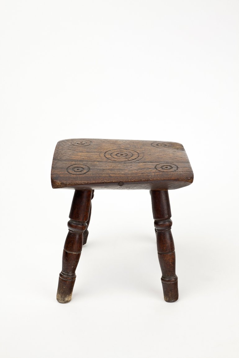 Witches Stool from Anne Hathaway's Cottage, C16th. Small wooden foot stool carved with five sets of rings known as 'Witches Marks'.