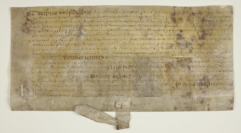 The manuscript, in fairly illegible Latin, has certain words picked out in larger script. There is a tag at the foot which once held a seal.