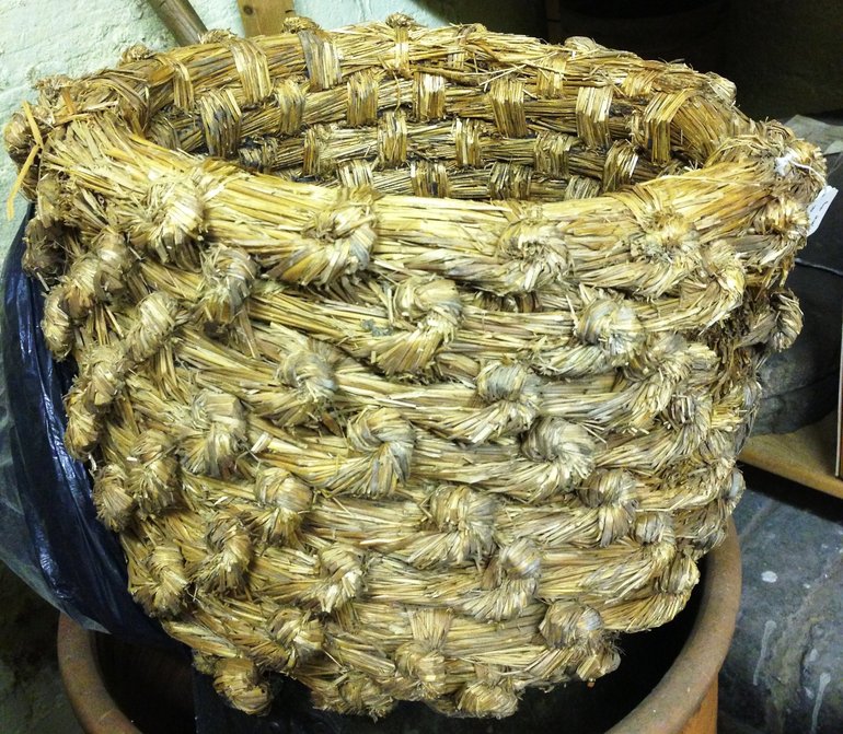 A straw bee skep, a shaped basket of woven straw.