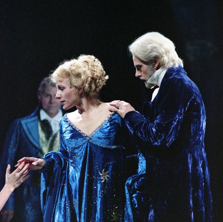 Leontes, white-haired and in a blue velvet jacket, has his hand on the shoulder of a younger lady in a blue silken dress, who is taking the hand stretched out by someone at a lower-level out of the picture.